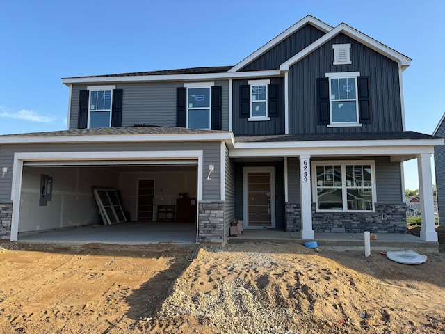 6259 Highland Hills Ln S, Cottage Grove, MN 55016 - view of front facade featuring stone siding, board and batten siding, driveway, covered porch, and a garage