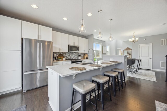 4343 Corn Silk Ln, Woodbury, MN 55129 - kitchen with appliances with stainless steel finishes, light countertops, recessed lighting, white cabinets, and dark wood-style floors