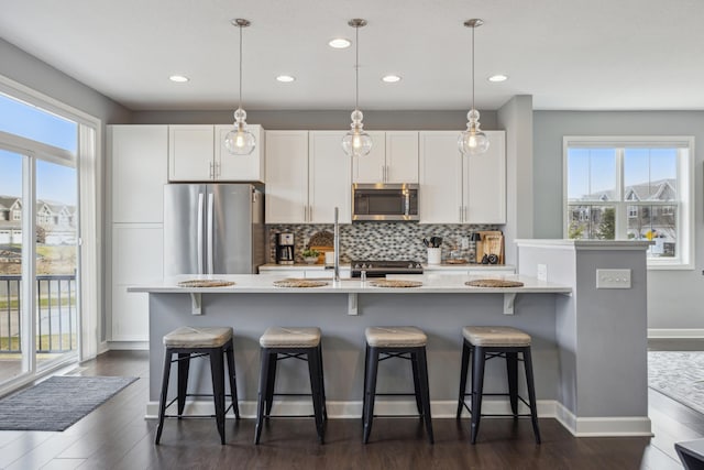 4343 Corn Silk Ln, Woodbury, MN 55129 - kitchen with appliances with stainless steel finishes, healthy amount of natural light, decorative backsplash, recessed lighting, and light countertops