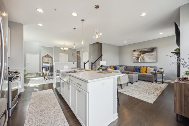 4343 Corn Silk Ln, Woodbury, MN 55129 - kitchen featuring appliances with stainless steel finishes, dark wood-style flooring, white cabinetry, a center island with sink, and recessed lighting