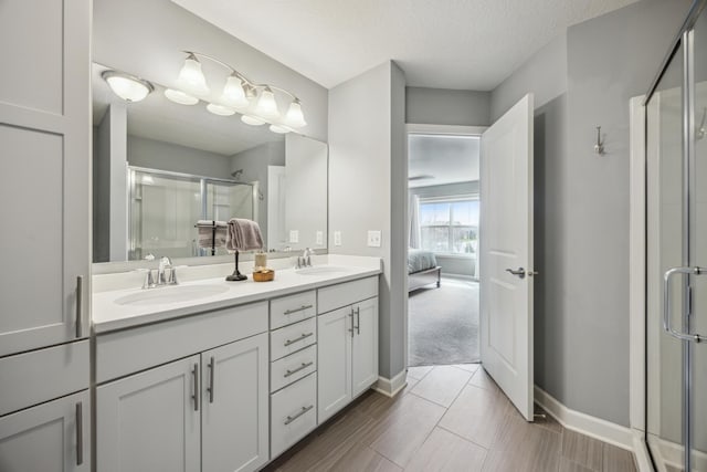 4343 Corn Silk Ln, Woodbury, MN 55129 - ensuite bathroom featuring double vanity, a stall shower, and a textured ceiling