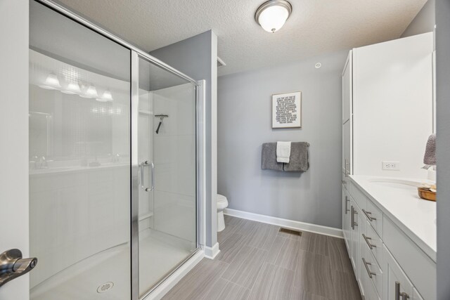 4343 Corn Silk Ln, Woodbury, MN 55129 - bathroom with a stall shower, vanity, and a textured ceiling