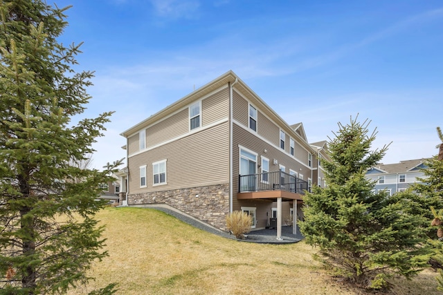 4343 Corn Silk Ln, Woodbury, MN 55129 - back of house with a yard, stone siding, and a wooden deck