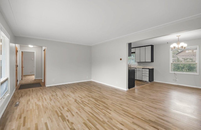 314 Orchard St N, Northfield, MN 55057 - unfurnished living room with light wood-style floors, a chandelier, plenty of natural light, and baseboards