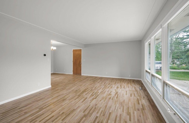 314 Orchard St N, Northfield, MN 55057 - unfurnished room with light wood finished floors, a chandelier, and baseboards