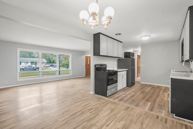 314 Orchard St N, Northfield, MN 55057 - kitchen featuring gas stove, freestanding refrigerator, a sink, stainless steel microwave, and light countertops