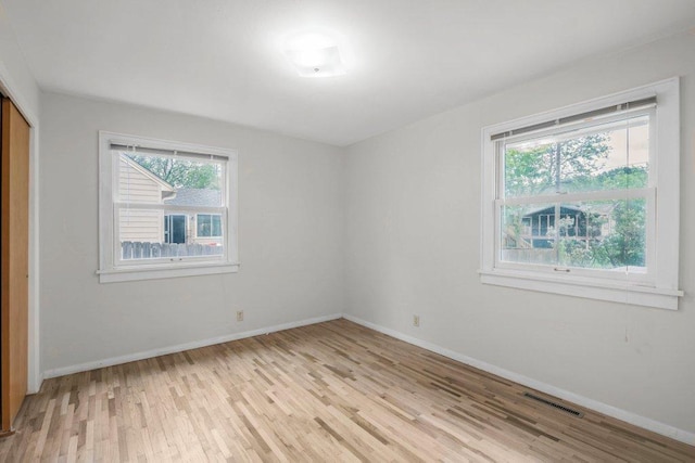 314 Orchard St N, Northfield, MN 55057 - unfurnished bedroom featuring light wood-style floors, multiple windows, and baseboards