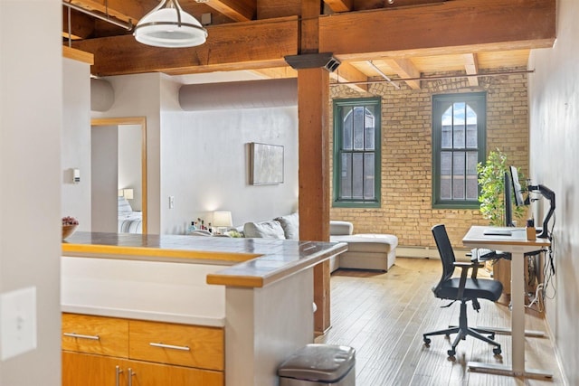 office with brick wall, beamed ceiling, hardwood / wood-style flooring, and washer / dryer
