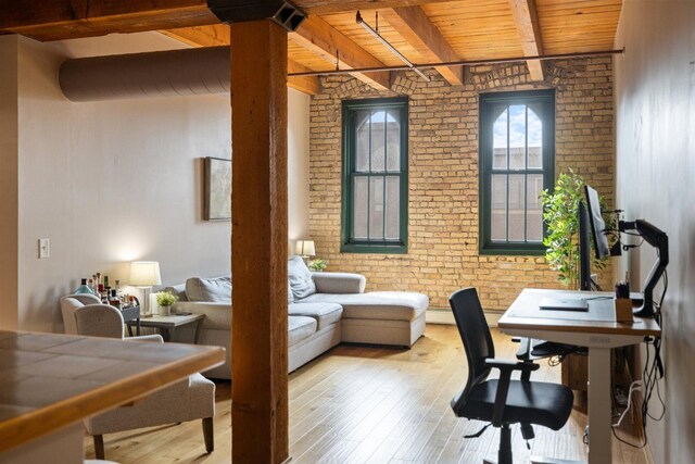 office space with wood ceiling, brick wall, beamed ceiling, and hardwood / wood-style flooring