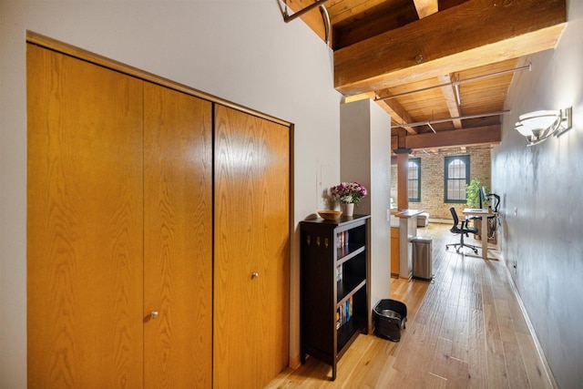 hall featuring beam ceiling, light wood-type flooring, wood ceiling, and baseboards