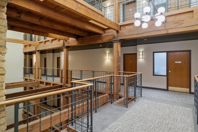 hall with an upstairs landing and a chandelier