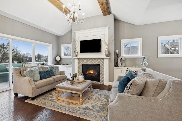 living room featuring vaulted ceiling with beams, a notable chandelier, dark wood-style flooring, and a tile fireplace