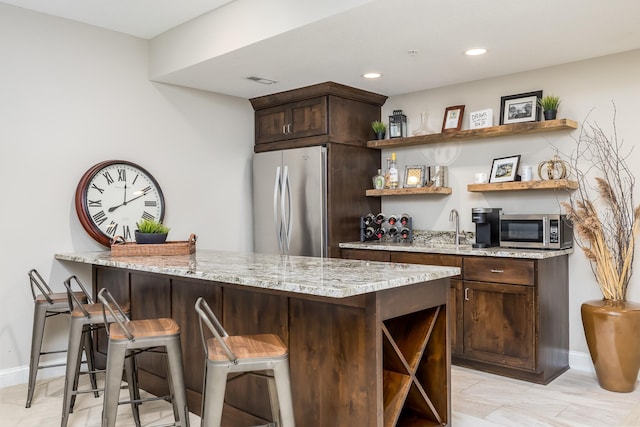 bar with a sink, stainless steel appliances, baseboards, recessed lighting, and wet bar