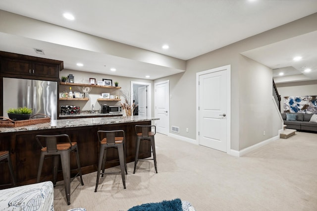 bar with stainless steel appliances, baseboards, recessed lighting, light carpet, and wet bar