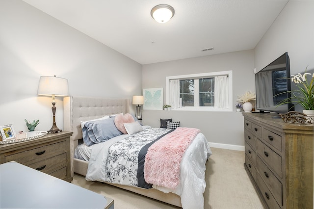 bedroom featuring visible vents, light colored carpet, and baseboards