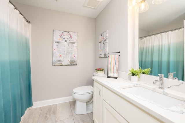 bathroom featuring vanity, toilet, marble finish floor, visible vents, and baseboards