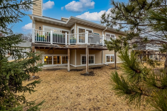 rear view of property with a chimney and a wooden deck
