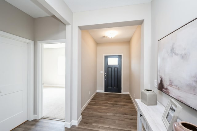 interior space featuring baseboards and dark wood-style flooring