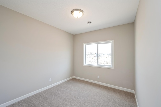 carpeted spare room with baseboards
