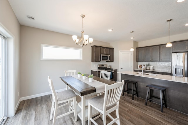 dining area featuring recessed lighting, an inviting chandelier, wood finished floors, and baseboards