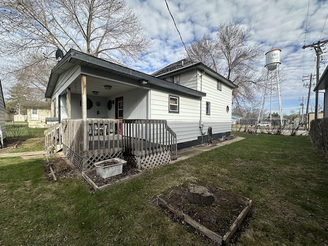 back of house featuring a lawn and covered porch