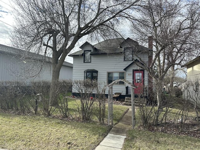 view of front of home with a chimney and a front lawn