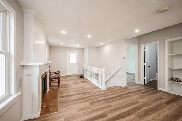 interior space featuring a fireplace, recessed lighting, baseboards, and light wood-style floors