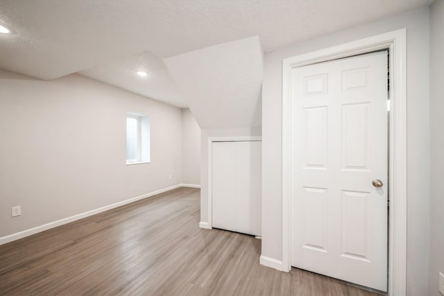 bonus room with baseboards, recessed lighting, and wood finished floors