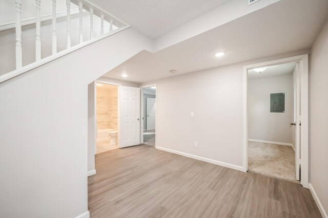 interior space featuring baseboards, electric panel, recessed lighting, and wood finished floors