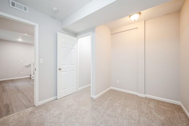 unfurnished bedroom featuring baseboards, carpet, and visible vents