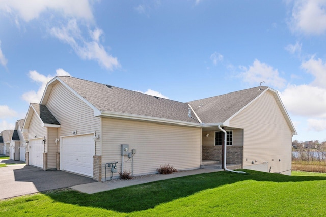 exterior space featuring a lawn, driveway, roof with shingles, and a garage