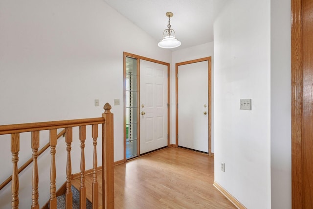 foyer entrance with baseboards and light wood finished floors