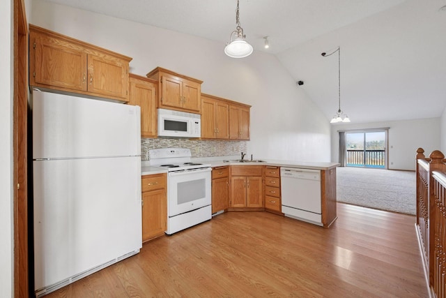 kitchen with white appliances, light countertops, a peninsula, decorative light fixtures, and light wood-type flooring
