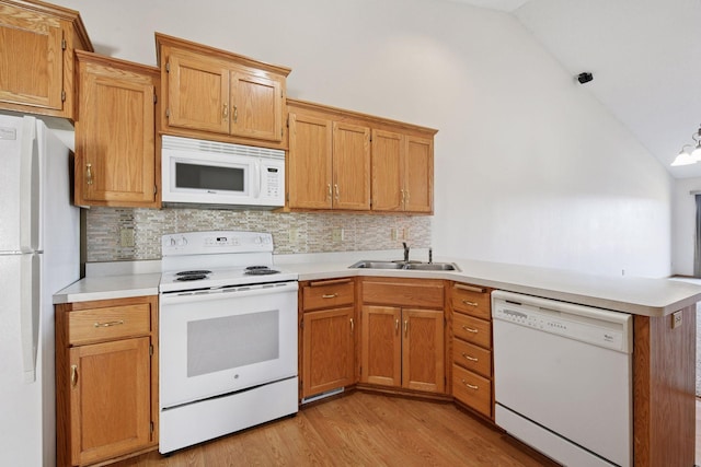 kitchen featuring decorative backsplash, vaulted ceiling, a sink, a peninsula, and white appliances