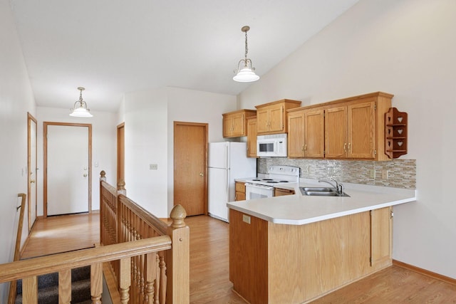 kitchen with decorative backsplash, white appliances, light wood-type flooring, light countertops, and a sink
