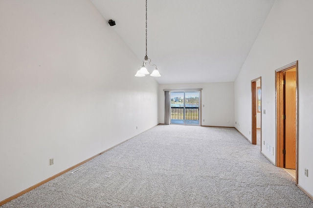unfurnished room with high vaulted ceiling, baseboards, a notable chandelier, and light colored carpet