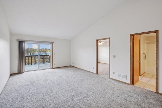 carpeted empty room with a ceiling fan, baseboards, visible vents, and high vaulted ceiling