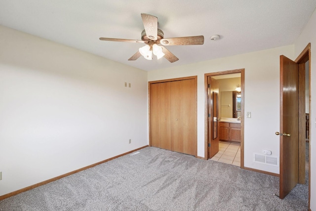 unfurnished bedroom featuring light colored carpet, baseboards, visible vents, and a closet