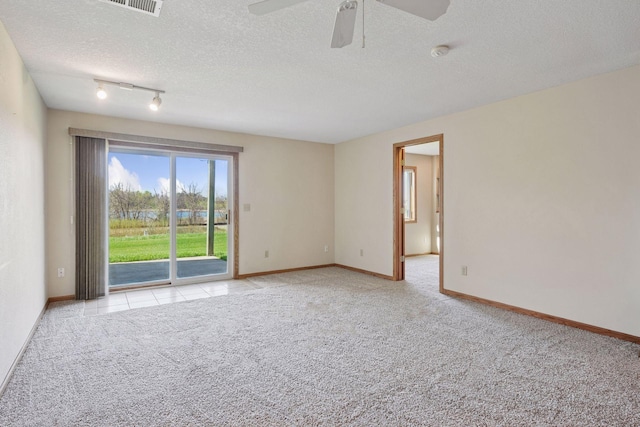 carpeted spare room featuring baseboards, a ceiling fan, a textured ceiling, and track lighting