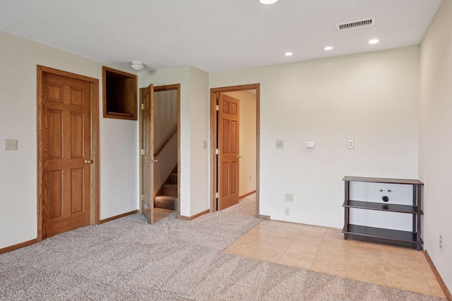 carpeted empty room featuring stairway, baseboards, recessed lighting, and visible vents