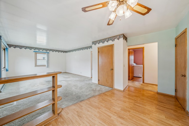 interior space featuring ceiling fan, baseboards, light wood-style floors, and washer / clothes dryer
