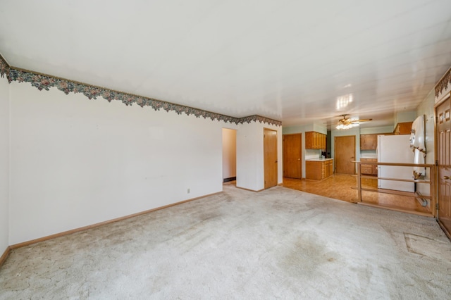 unfurnished room with baseboards, light carpet, and ceiling fan