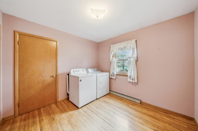 laundry room featuring a baseboard heating unit, light wood finished floors, laundry area, and washer and clothes dryer