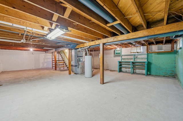 unfinished basement with stairway, heating unit, and water heater