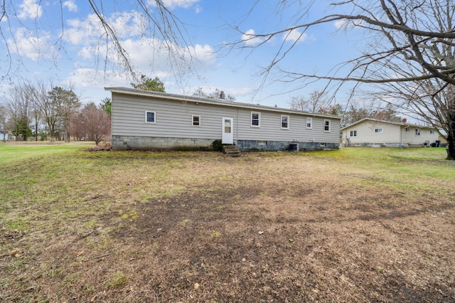 back of property featuring a lawn and entry steps