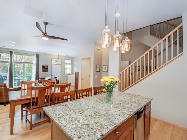 1586 Juno Ave Unit 14, Saint Paul, MN 55116 - kitchen featuring light wood-style flooring, ceiling fan with notable chandelier, open floor plan, and decorative light fixtures