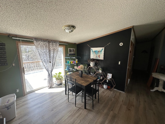 dining space featuring wood finished floors and a textured ceiling