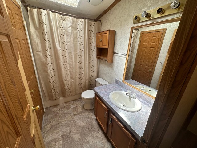 bathroom featuring vanity, shower / bath combo with shower curtain, toilet, crown molding, and stone finish floor