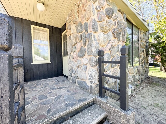 doorway to property with stone siding