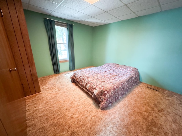 bedroom with a paneled ceiling and carpet